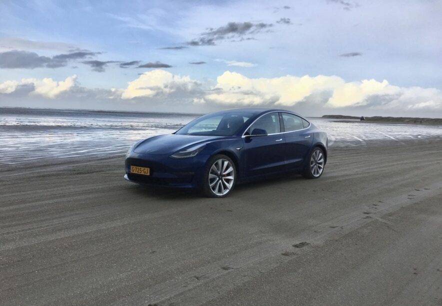 Een Tesla Model 3 op het strand