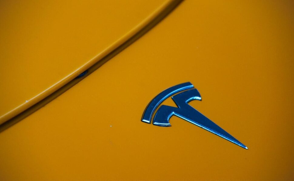 De badge op een oranje Tesla Roadster